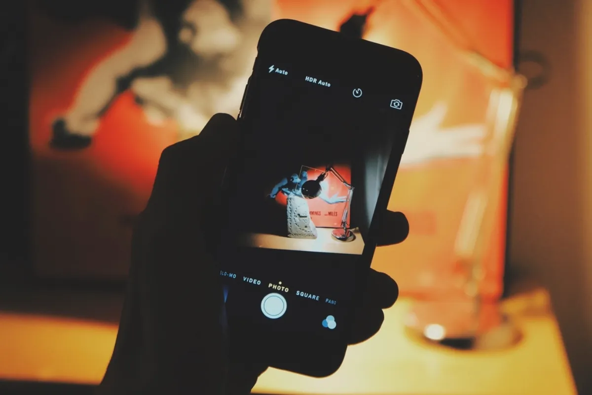 Hand holding a smartphone camera, illustrating the AI face photo cancer survival study