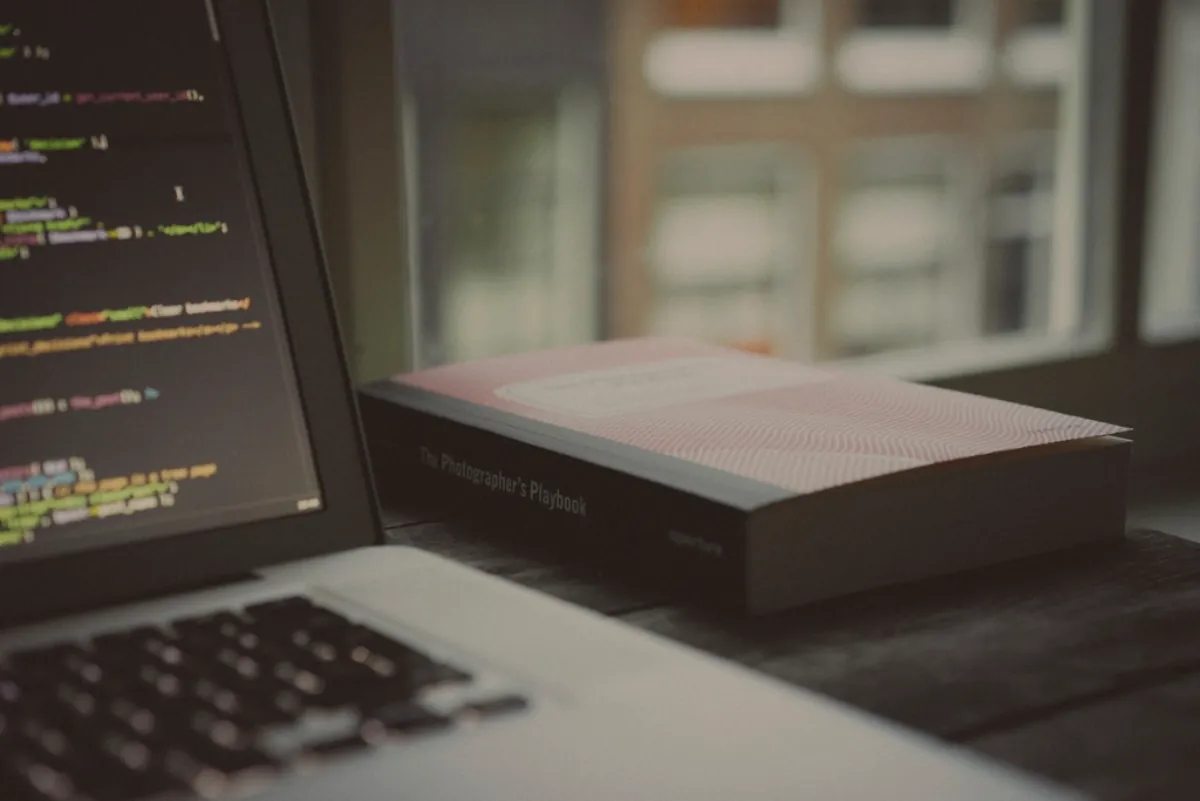 Laptop showing code on a desk, illustrating Infosys Q2 results and IT sector news