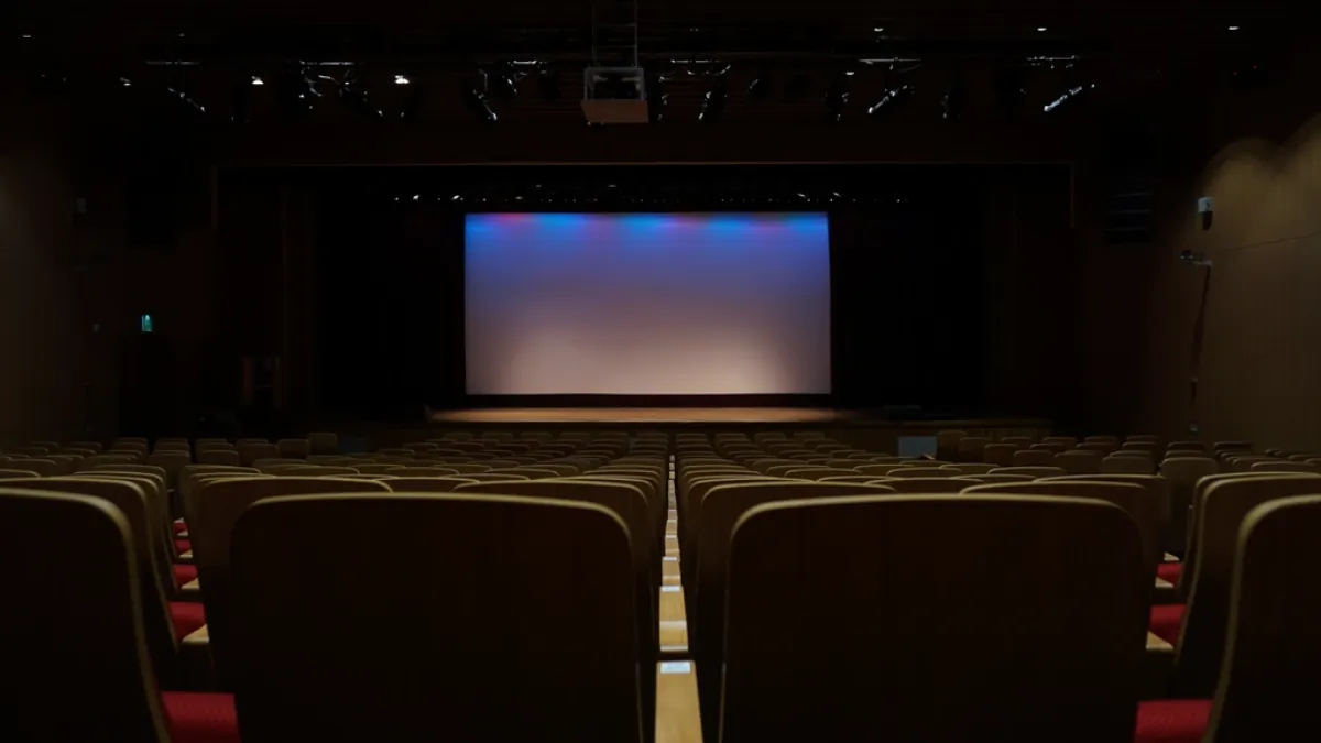 Empty cinema hall with a lit screen, illustrating the Rashmika Mandanna accent row